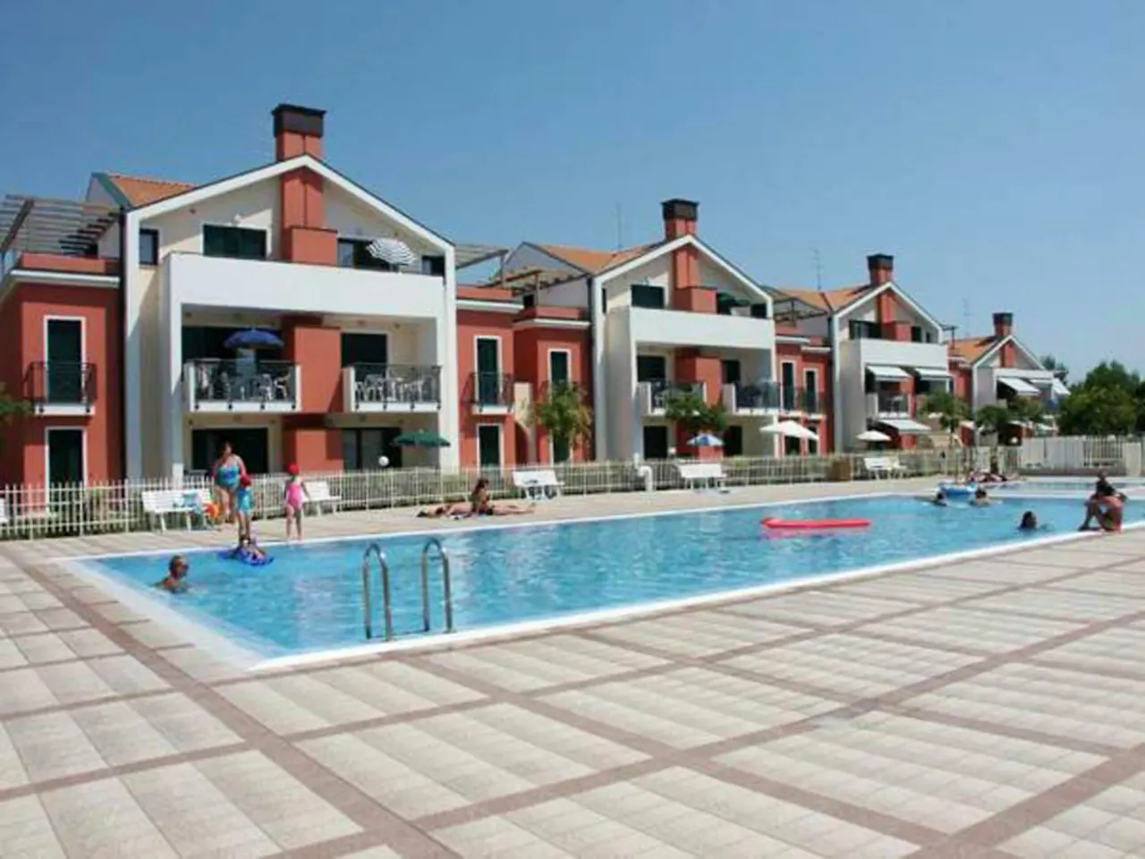 BookNoFees: poilsio būstas, Cavallino-Treporti, Italija – žmonių grupė baseine šalia „Sunny Apartment On The Sea“ pastatų Kavallino-Treporti mieste
