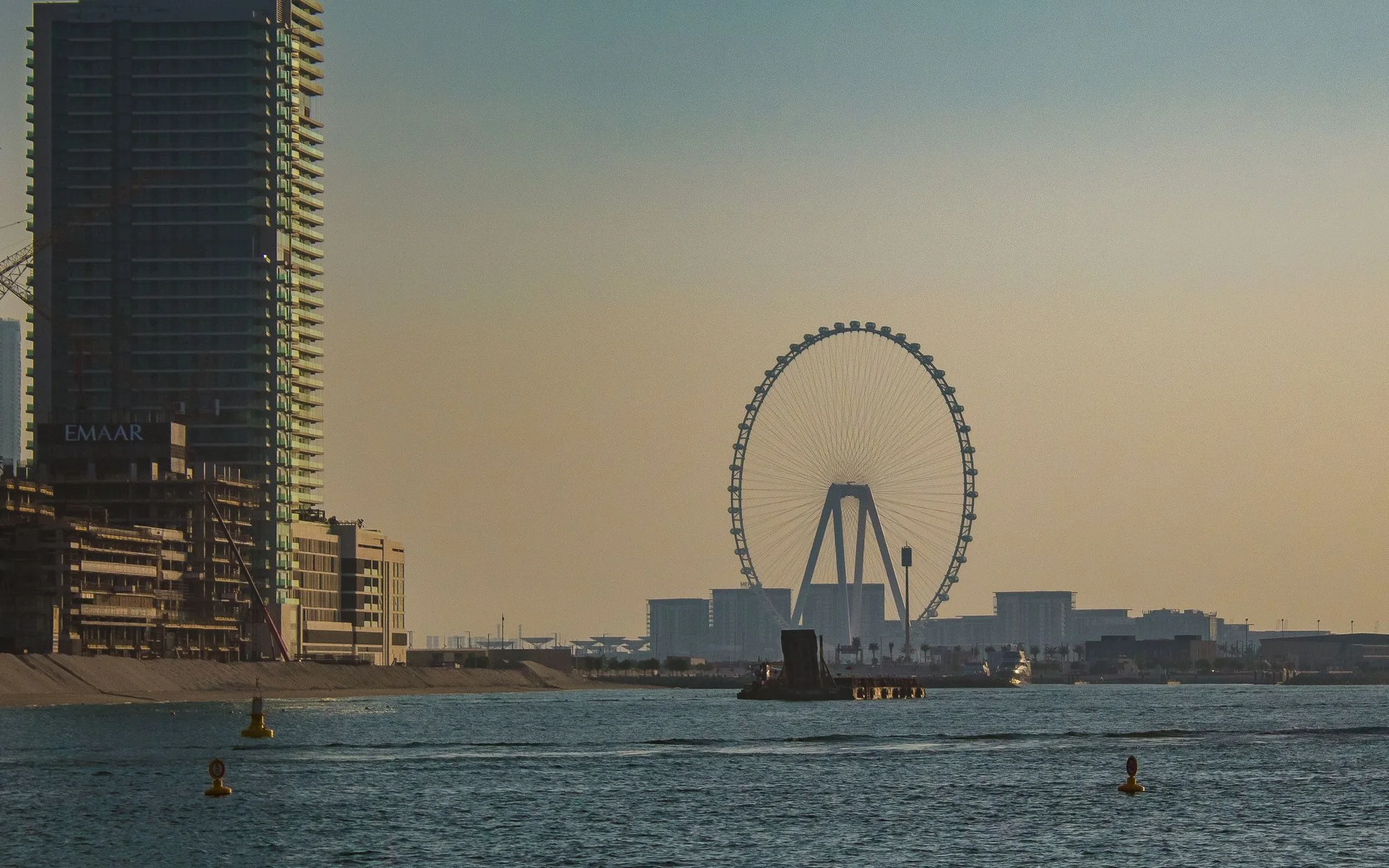 Dubajaus panoramos vaizdas su didžiuliu ratu saulėlydžio metu