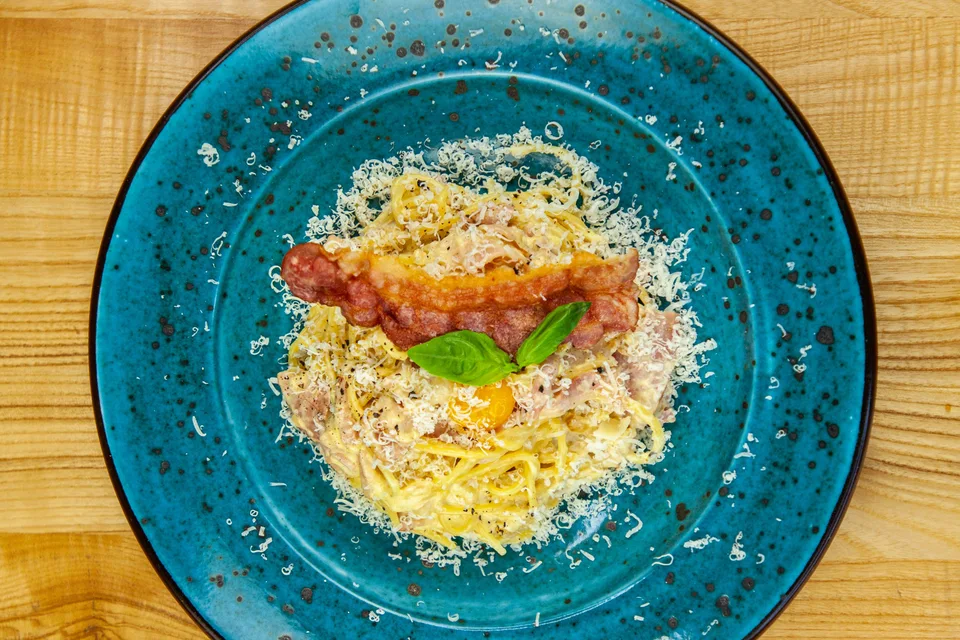 BookNoFees: Iliustracinė nuotrauka: Spagečiai carbonara mėlynoje lėkštėje